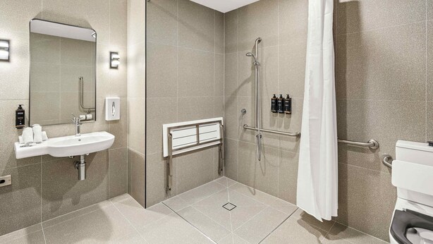 A modern bathroom with a shower, a sink, and a toilet. - Mercure Pakenham (Pakenham)