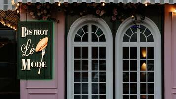 Un edificio con un letrero que dice 'BISTROT Le Mode' y dos ventanas de arco.