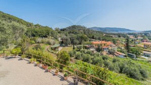 A hillside property with a view of a village below.