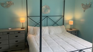 Un letto a baldacchino con biancheria bianca, due comodini con lampade e decorazioni a parete.