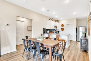 A modern kitchen with white cabinets, a wooden dining table, and black chairs. - 5 min to Branson Strip, 8 min to SDC, Panoramic View! (Branson)