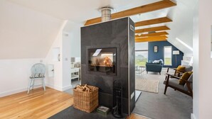 Un loft moderne doté d’une cheminée intégrée, de poutres en bois et d’un coin salon confortable.