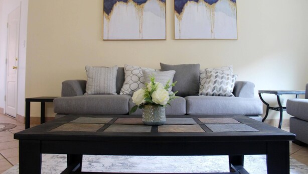 A living room with a grey sofa, a black coffee table, and two abstract paintings on the wall. - Spacious Escape, 1KB, 2QB, Wifi - Private Yard (Albuquerque)