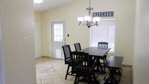 A dining area with a table and chairs, a chandelier, and a 'KITCHEN' sign. - Spacious Escape, 1KB, 2QB, Wifi - Private Yard (Albuquerque)