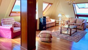 Un espacioso dormitorio tipo loft con techos altos, tragaluces y un amplio ventanal.