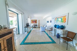 Un hall d’entrée spacieux, doté d’un sol carrelé, d’un tapis bleu et d’une cheminée agrémentée de vases décoratifs.