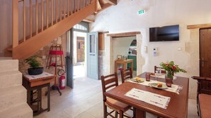 A dining area with a wooden table, chairs, and a staircase. - DOMUS CLODIA, sensing Rethymno's Old Town! (Rethymno)