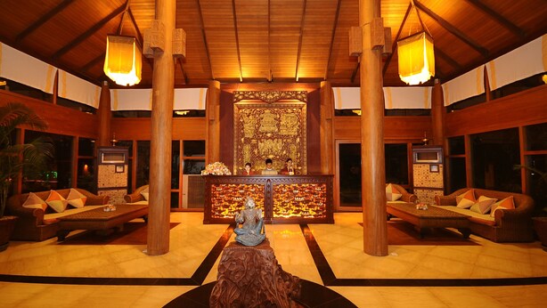 A lobby with a central statue, wooden pillars, and a reception desk with a decorative backdrop. - One Myanmar Resort Nay Pyi Taw (Naypyidaw)