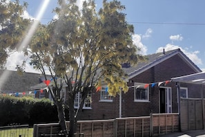 A residential building with a brick facade, a sloped roof, and a visible front door.
