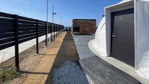 A pathway leading to a building with a door marked '03'. - EIGHT POINT RESORT AWAJISHIMA - Glamping (Awaji)