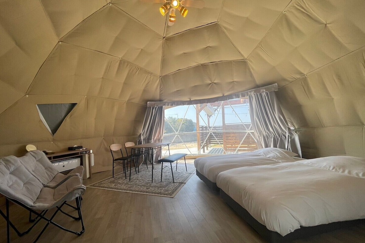 A tent-style room with a bed, a desk, and a chair.