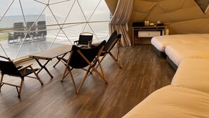 A tented room with a bed, a desk, and two chairs. - EIGHT POINT RESORT AWAJISHIMA - Glamping (Awaji)