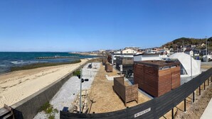 A coastal property with a sandy beach, wooden structures, and a view of the sea. - EIGHT POINT RESORT AWAJISHIMA - Glamping (Awaji)