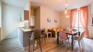 Une cuisine moderne avec un îlot central, un coin repas avec des chaises et un canapé.