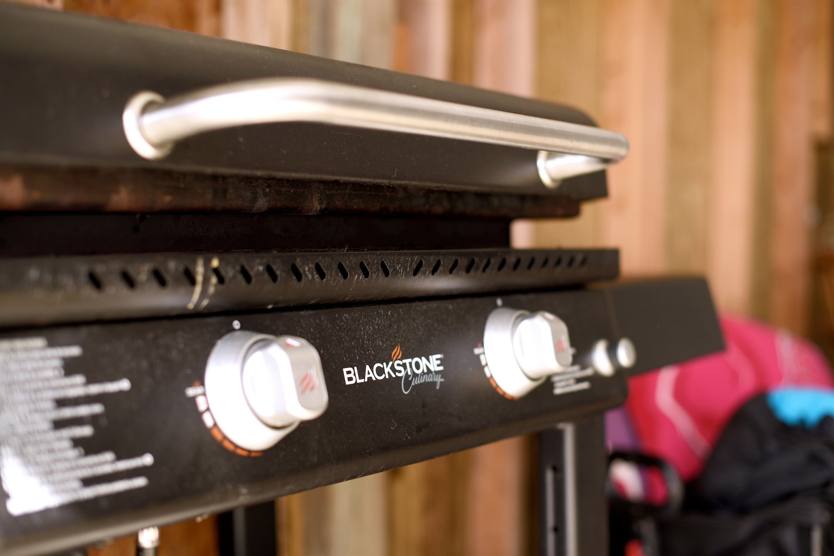 A close-up of a Blackstone Culinary grill with control knobs and a handle.