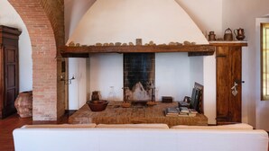 Un soggiorno accogliente con un camino, una panca di legno e una libreria.