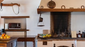 Un'accogliente zona pranzo con un arco in mattoni, un camino e un lampadario.