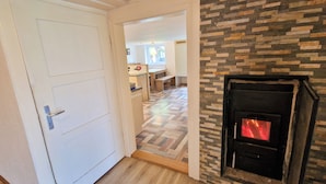 A hallway leading to a kitchen with a fireplace. - Quaint farmhouse in the countryside with its own garden, 10 beds (Weitnau)