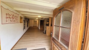A hallway with wooden flooring, a decorative wall with text, and a wooden door with glass panels. - Quaint farmhouse in the countryside with its own garden, 10 beds (Weitnau)