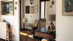 A dining area with a wooden table, chairs, a radiator, and a lamp. - Vesime Villa with Garden (Vesime (AT))