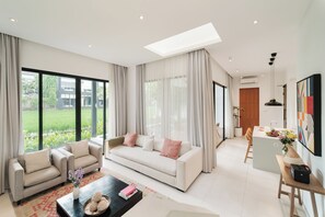 A spacious living room with a sofa, coffee table, and dining area.