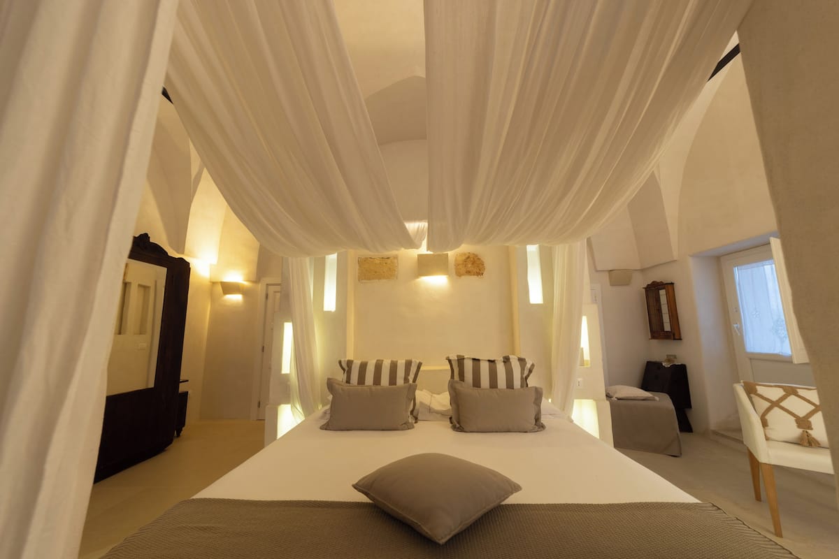 Une chambre avec un grand lit, deux tables de chevet et une chaise.
