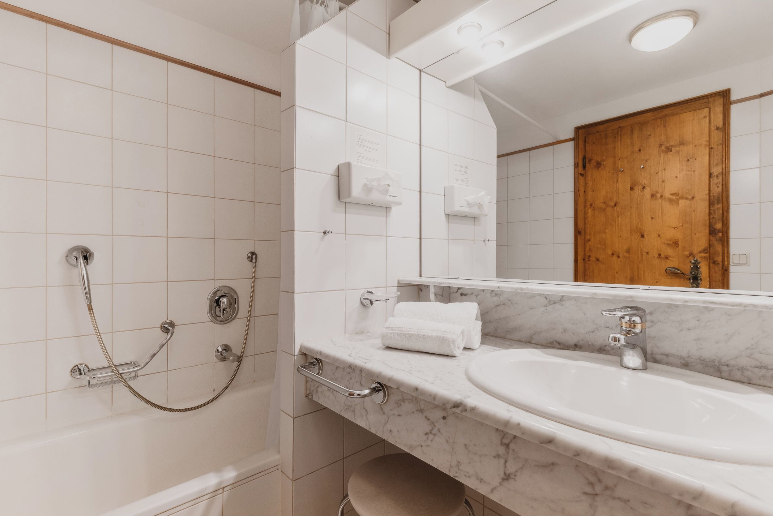 Ein Badezimmer mit Dusche, Waschbecken und Spiegel.