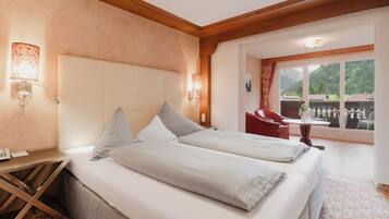 A hotel room with a bed, bedside lamps, a desk, and a view of the outdoors.