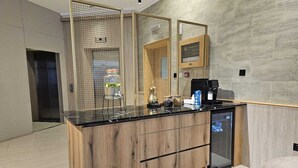 Uma cozinha moderna com bancada de madeira, cafeteira e geladeira.