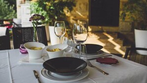 A table set for dining with white and black plates, bowls, and wine glasses. - Hotel Casona del Nansa (Herrerias)