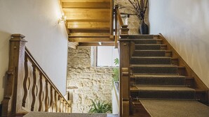 A wooden staircase with carpeted steps leading to a stone wall and a window. - Hotel Casona del Nansa (Herrerias)