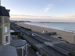 Une route côtière bordée d’une plage et d’une promenade.