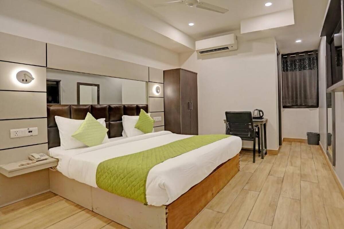 Una habitación de hotel moderna con una cama grande, una mesita de noche y un escritorio con una silla.