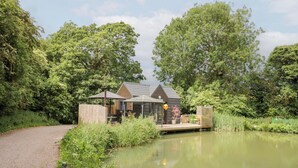 Ein Haus mit Teich, umgeben von Bäumen.