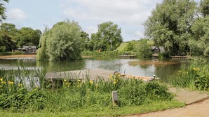Ein friedlicher See mit hölzernen Stegen und einem Pavillon.