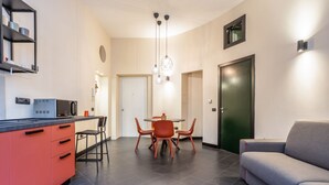 Una cucina moderna con zona pranzo, divano e una porta.