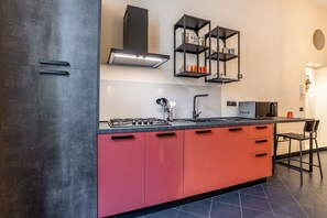 Une cuisine moderne équipée d’une cuisinière à gaz, d’un évier et d’un four à micro-ondes encastré.