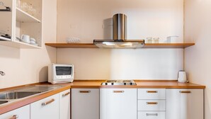 A compact kitchen with a built-in oven, a microwave, and a gas stove.