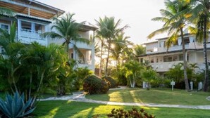 A resort with multiple-story buildings, a well-maintained lawn, and palm trees. - Family Dominicus Apartment - Bayahibe (Bayahibe)