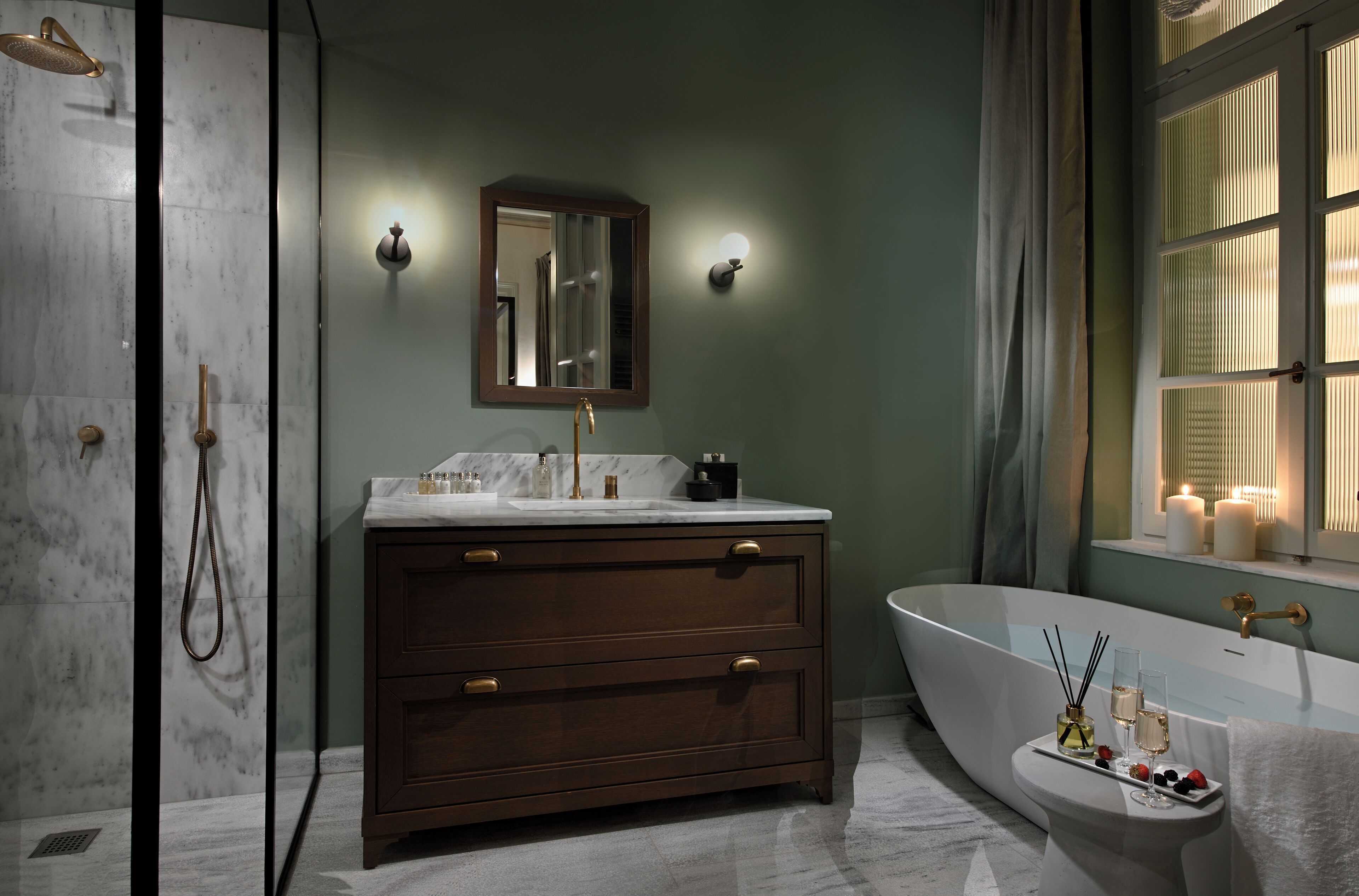 Un bagno con una vasca freestanding, un mobile lavabo con specchio e uno spazio doccia.