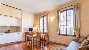 A compact living space with a kitchenette, dining area, and a sofa.