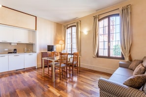 A compact living space with a kitchenette, dining area, and a sofa.