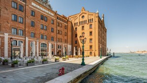 Un paseo marítimo con mesas al aire libre, un canal y edificios históricos.