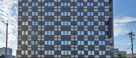 A modern hotel with a grid of windows and a flat roof.