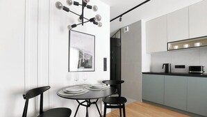 Una cocina moderna con armarios grises, una encimera negra y una lámpara colgante.