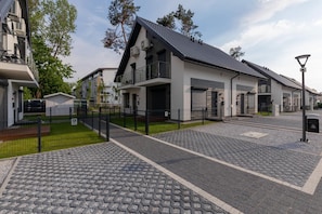Un bâtiment moderne doté d’un toit plat, de plusieurs portes de garage et d’une allée d’entrée pavée.