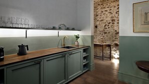 Una cucina con un piano di lavoro in legno, un lavello e un muro in pietra.