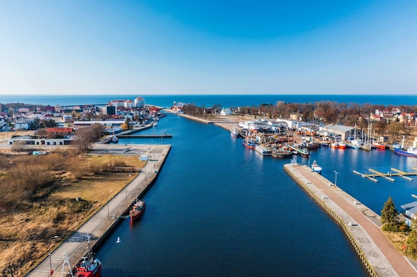Un port de plaisance avec des bateaux amarrés, un ciel dégagé et une vue sur la ville environnante.
