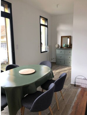 A dining area with a round table, chairs, a dresser, and a mirror.