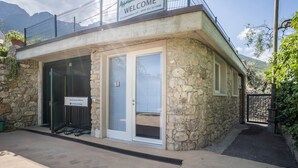 Un edificio in pietra con un cartello che dice 'WELCOME', una porta in vetro e un cancello in metallo.